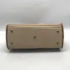 Dooney & Bourke All Weather Leather bone and British tan pebbled leather buckle crossbody satchel