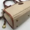 Dooney & Bourke All Weather Leather bone and British tan pebbled leather buckle crossbody satchel