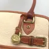 Dooney & Bourke All Weather Leather bone and British tan pebbled leather buckle crossbody satchel